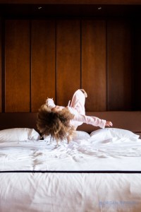 little girl jumping on the bed
